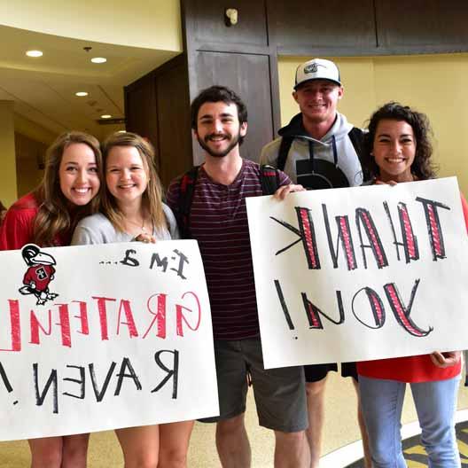 Students holding thank you signs during Grateful Raven Day